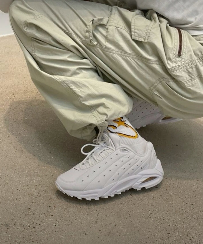 Les baskets Nike Hot Step Air Terra NOCTA "White" Femme, issues de la collaboration avec Drake, allient l'élégance du blanc immaculé avec la performance technique.