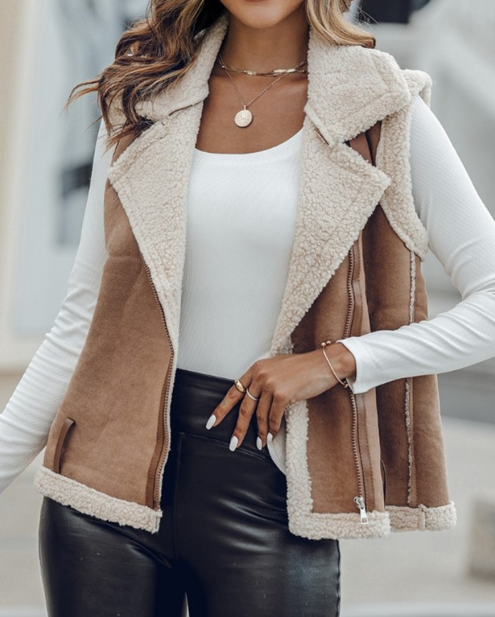 Premièrement : Affirmez votre look avec cette Veste sans manches à col cranté en polyuréthane avec poche avant et chaîne pour automne et hiver femme.