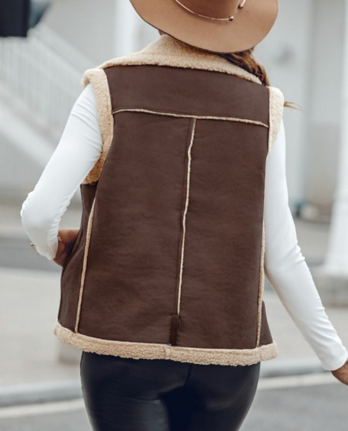 Premièrement : Affirmez votre look avec cette Veste sans manches à col cranté en polyuréthane avec poche avant et chaîne pour automne et hiver femme.