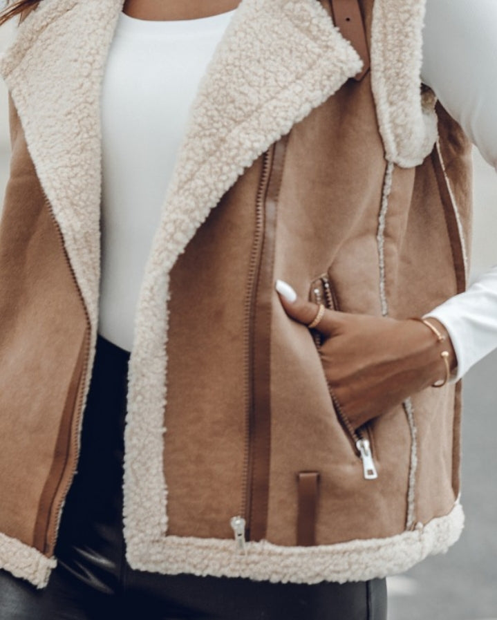 Premièrement : Affirmez votre look avec cette Veste sans manches à col cranté en polyuréthane avec poche avant et chaîne pour automne et hiver femme.
