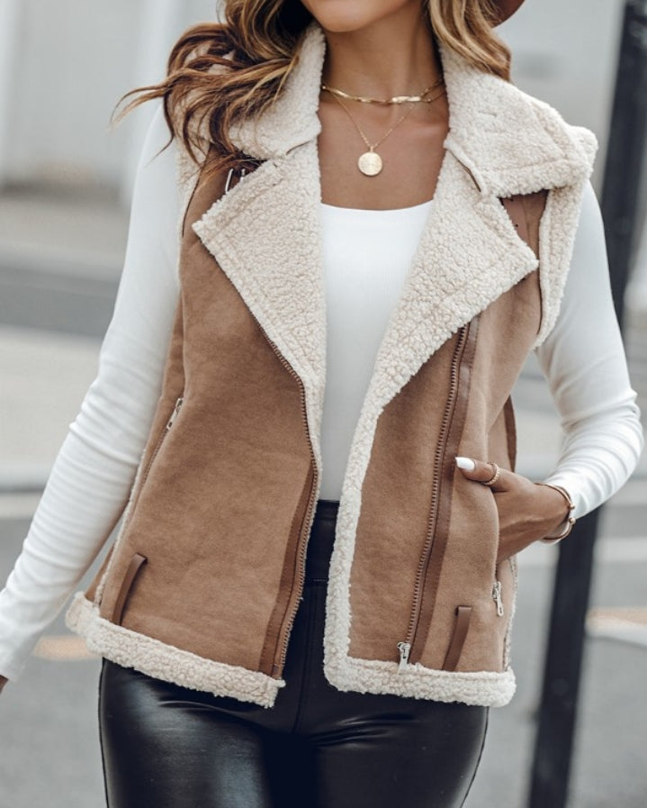 Premièrement : Affirmez votre look avec cette Veste sans manches à col cranté en polyuréthane avec poche avant et chaîne pour automne et hiver femme.