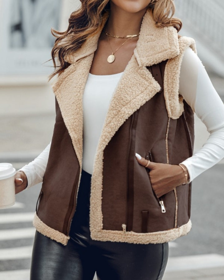 Premièrement : Affirmez votre look avec cette Veste sans manches à col cranté en polyuréthane avec poche avant et chaîne pour automne et hiver femme.
