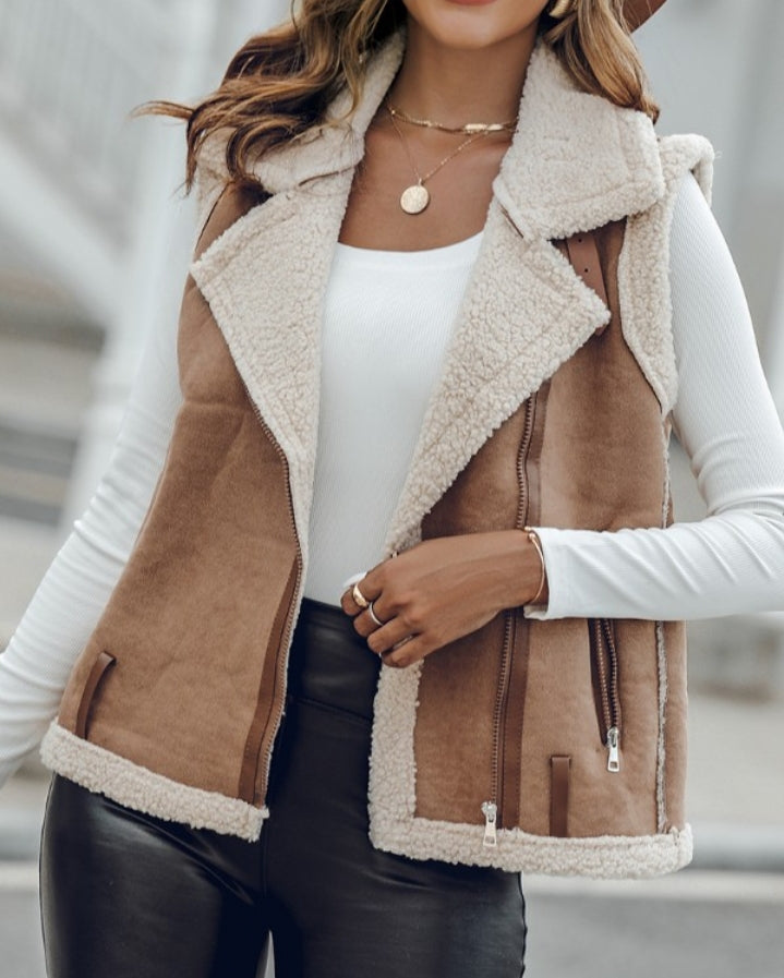 Premièrement : Affirmez votre look avec cette Veste sans manches à col cranté en polyuréthane avec poche avant et chaîne pour automne et hiver femme.