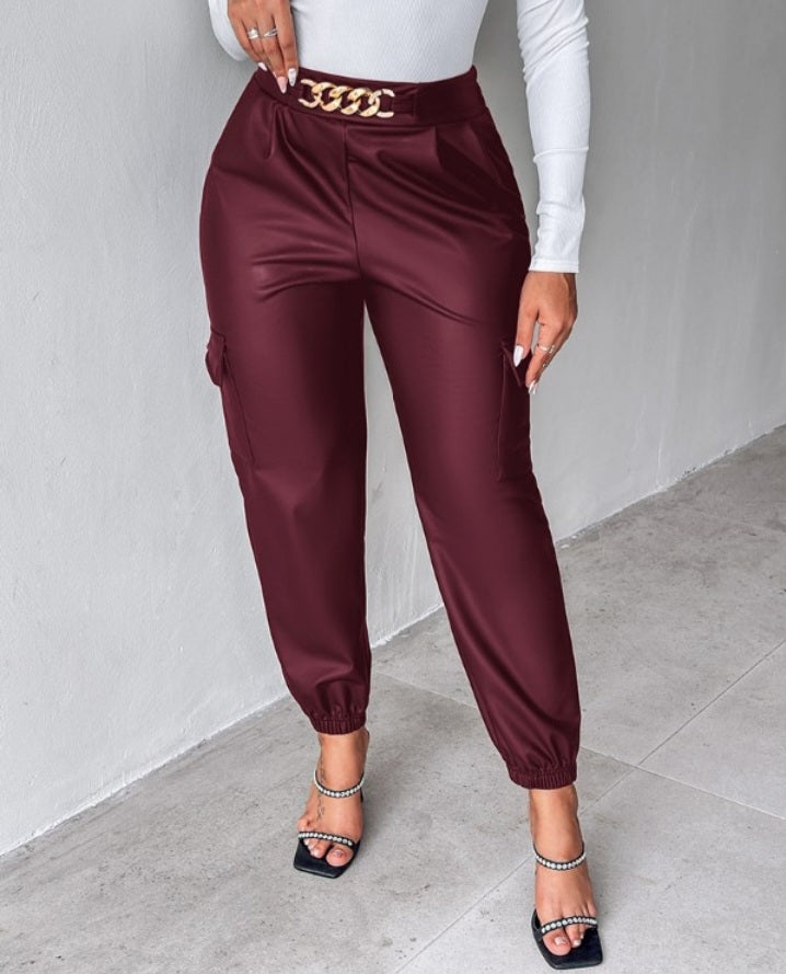 Premièrement : Ce Pantalon cargo taille haute en cuir PU avec poche à rabat et décoration en chaîne femme .