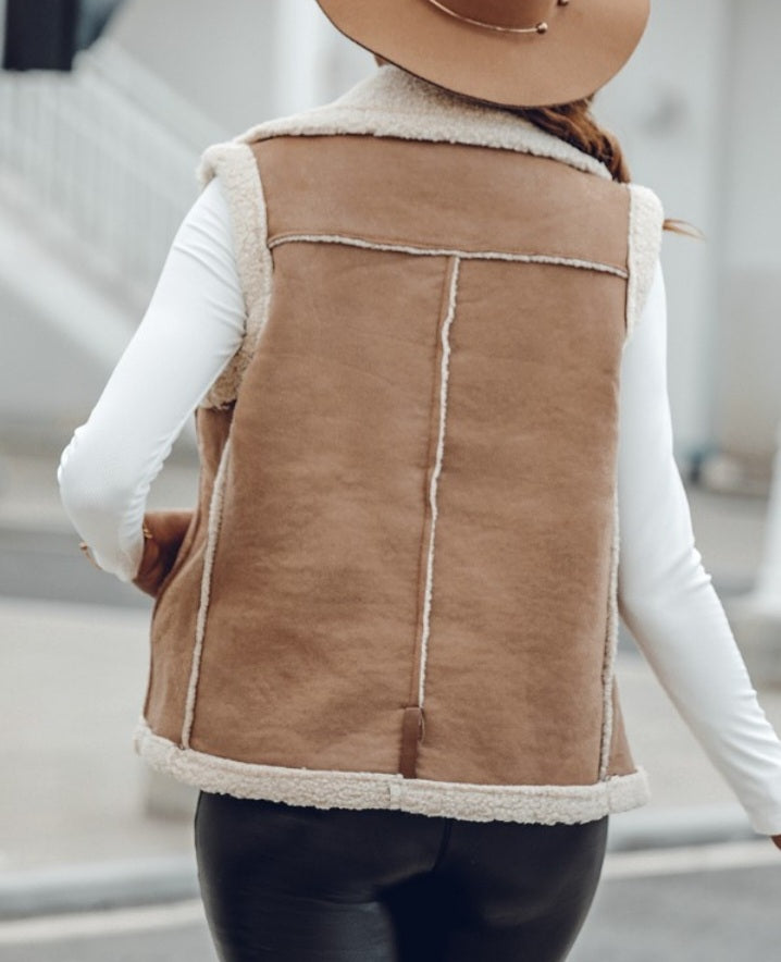 Premièrement : Affirmez votre look avec cette Veste sans manches à col cranté en polyuréthane avec poche avant et chaîne pour automne et hiver femme.