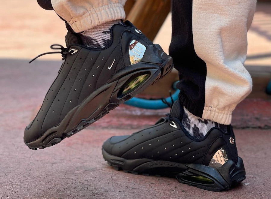 Les baskets Nike Hot Step Air Terra x Drake NOCTA "Red" Femme, issues de la collaboration entre Nike et NOCTA, incarnent l’alliance parfaite entre le style signature de Drake et l’expertise technique de Nike.