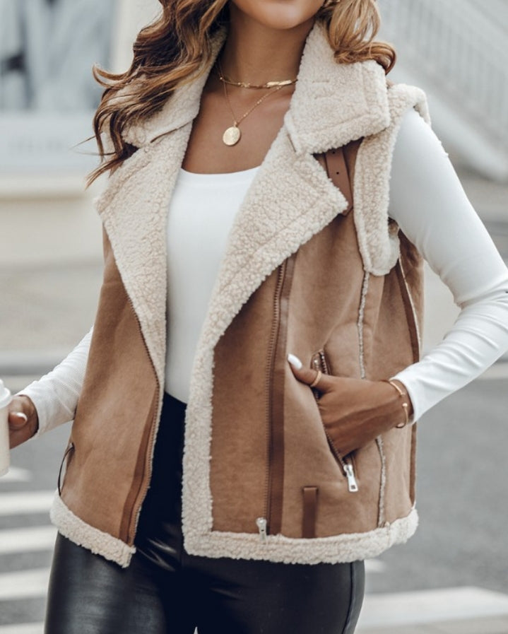 Premièrement : Affirmez votre look avec cette Veste sans manches à col cranté en polyuréthane avec poche avant et chaîne pour automne et hiver femme.