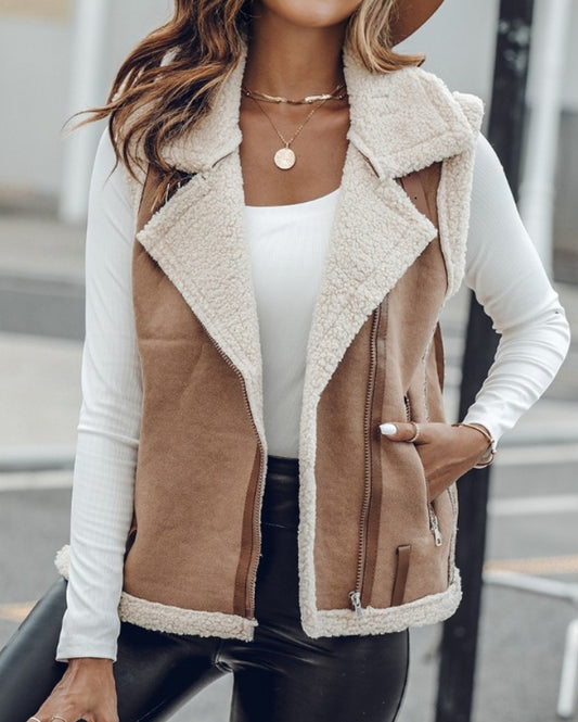 Premièrement : Affirmez votre look avec cette Veste sans manches à col cranté en polyuréthane avec poche avant et chaîne pour automne et hiver femme.