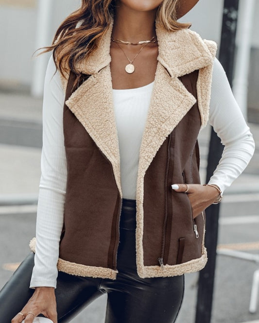 Premièrement : Affirmez votre look avec cette Veste sans manches à col cranté en polyuréthane avec poche avant et chaîne pour automne et hiver femme.
