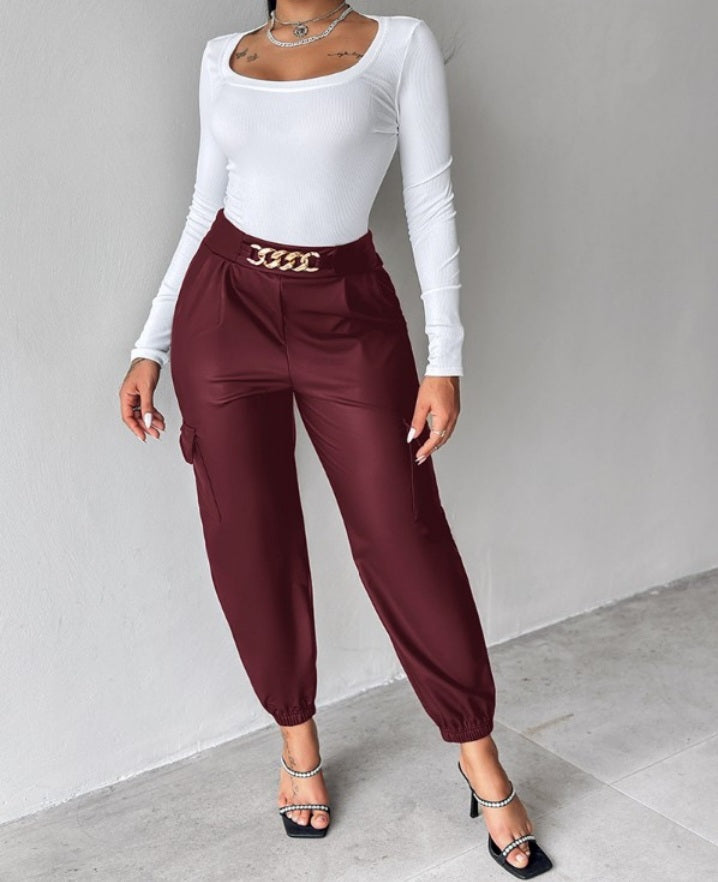 Premièrement : Ce Pantalon cargo taille haute en cuir PU avec poche à rabat et décoration en chaîne femme .