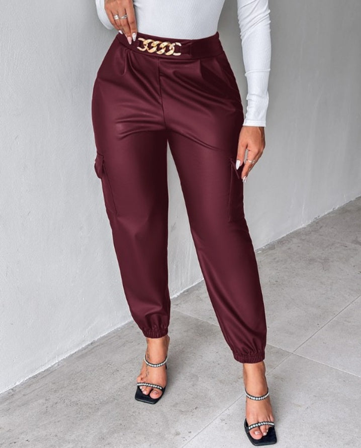 Premièrement : Ce Pantalon cargo taille haute en cuir PU avec poche à rabat et décoration en chaîne femme .