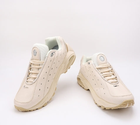 Les baskets Nike Hot Step Air Terra x Drake NOCTA "Beige-Cream" Femme incarnent la rencontre entre le style moderne de Drake et la technicité emblématique de Nike.